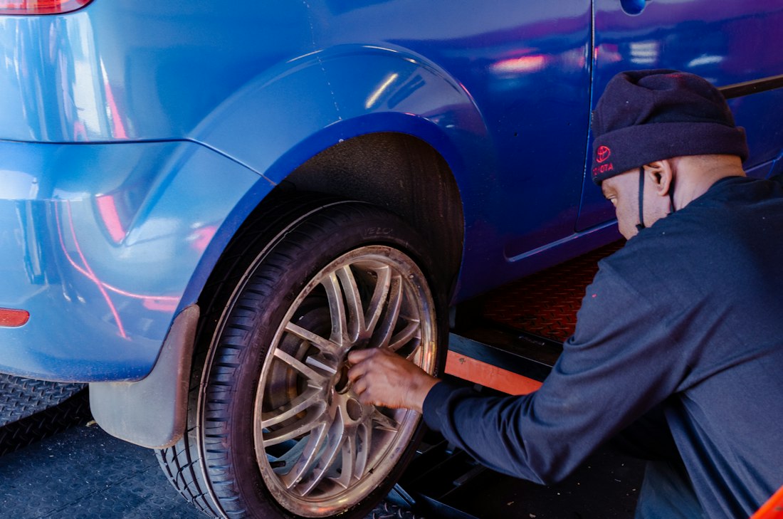 Mechanic swapping a tire beside a car